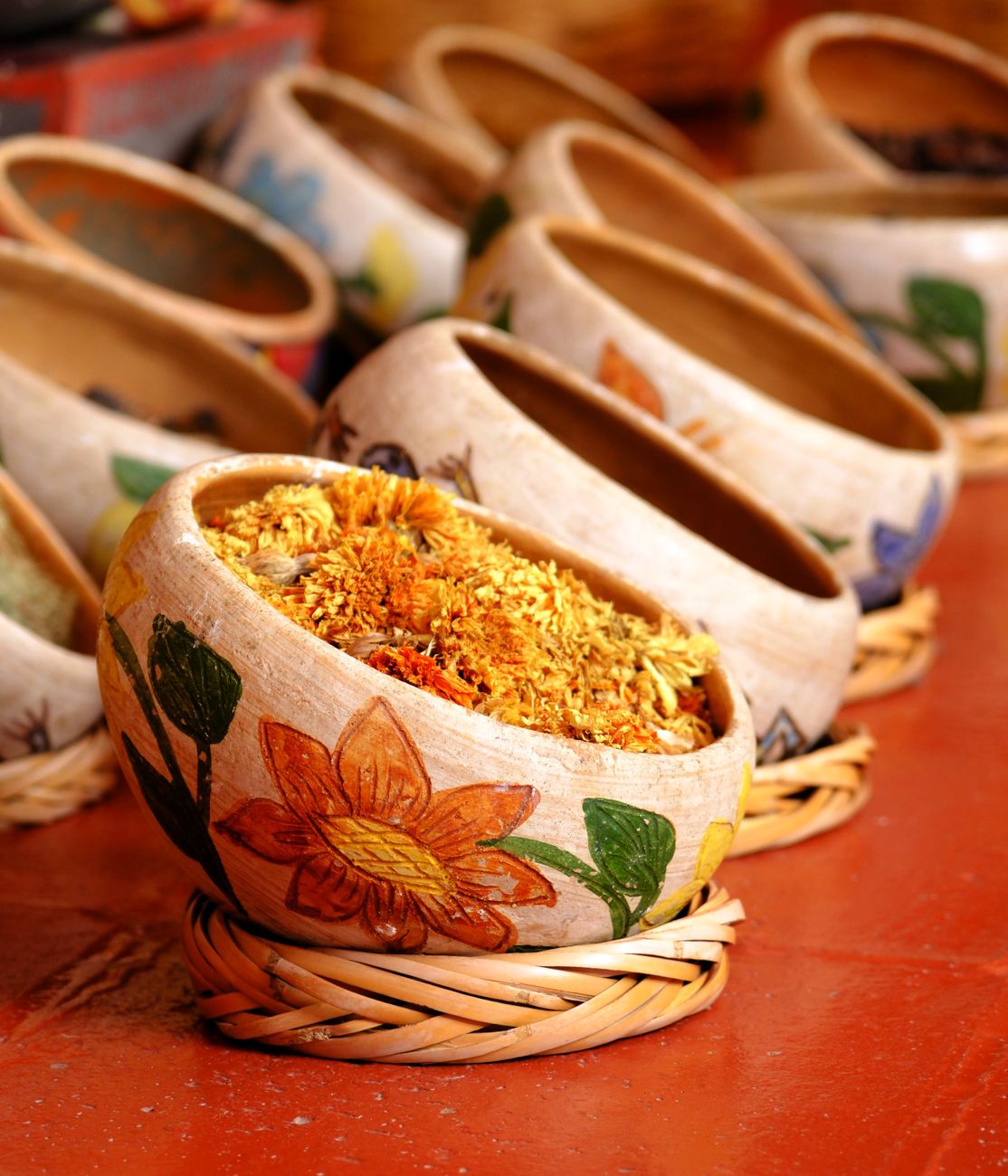 Clay bowls of mole, herbs and dried chilies in market stall